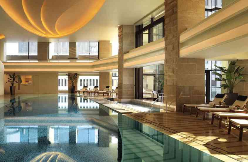 espreguiçadeiras em frente a piscina coberta em área de lazer de um dos melhores hotéis no japão