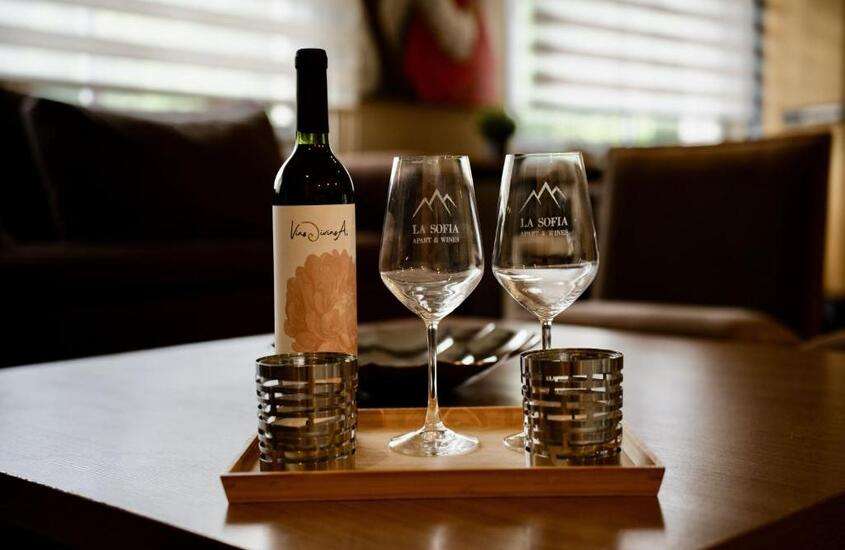 taças de vidro e garrafa de vinho em cima de mesa de madeira
