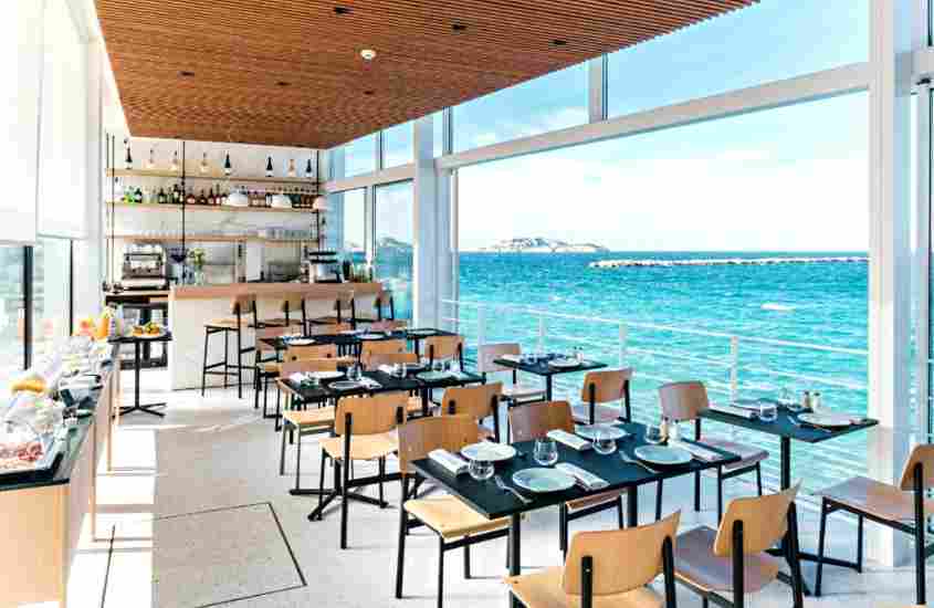 durante o dia, mesas e cadeiras em restaurante de hotel em marselha com vista para o mar