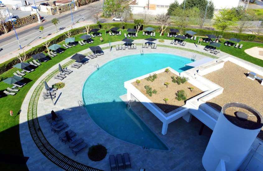 durante o dia, vista aérea de guarda-sóis e espreguiçadeiras ao redor de piscina em um dos melhores hotéis em sevilha