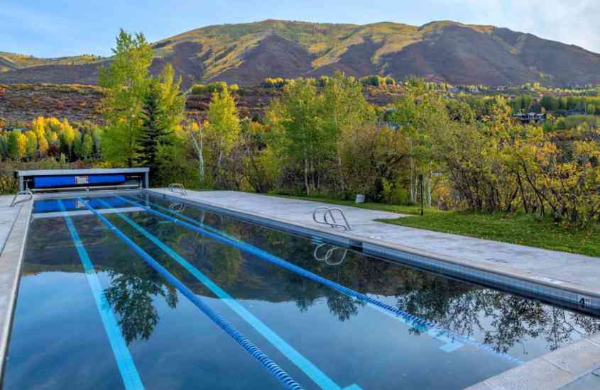 durante o dia, piscinas ao redor grande piscina retangular e, ao fundo, montanhas