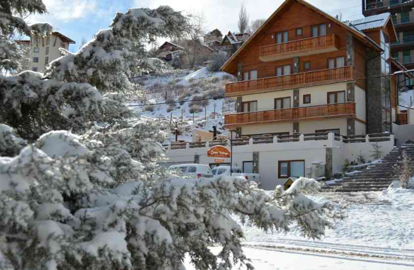 durante o dia, árvores nevadas em frente a prédio de madeira, um hotel onde ficar no Valle Nevado