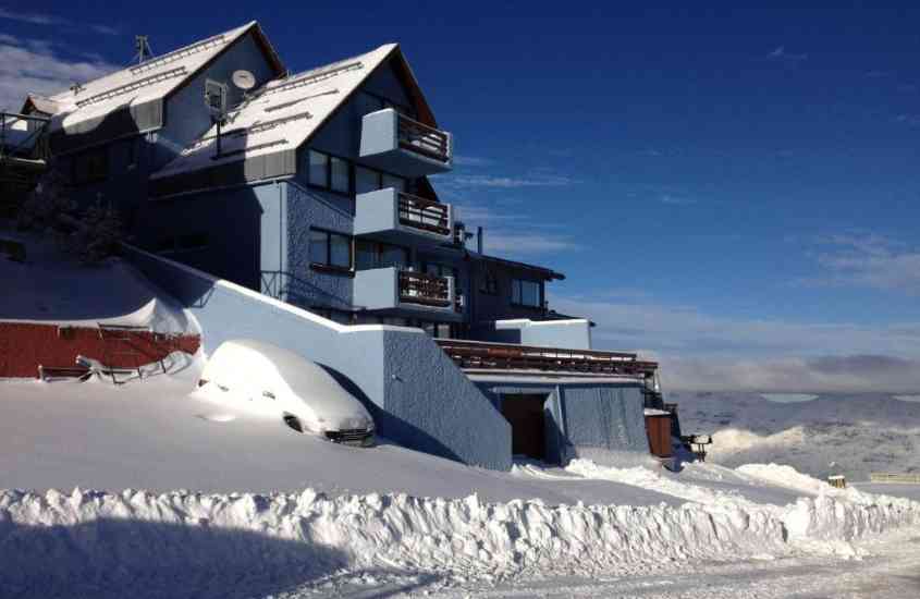 durante o dia, carro coberto de neve em frente a casa azul, um hotel onde se hospedar no valle nevado