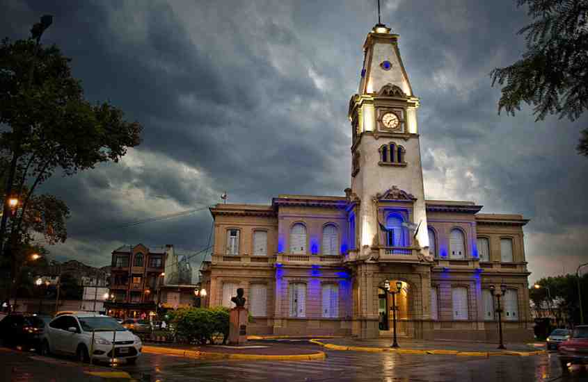 durante dia nublado, carros passando em frente a igreja iluminada por luzes azuis