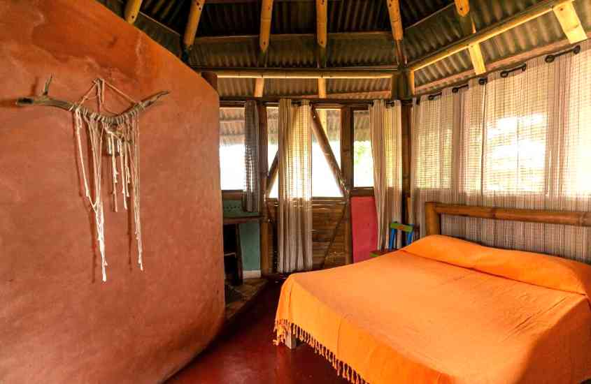 cama de casal em tenda feita com bambu em um dos campings de luxo