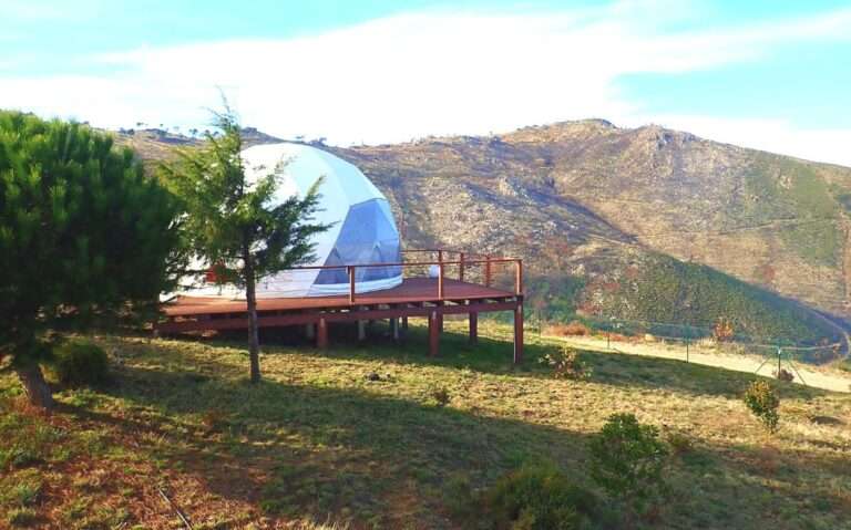 durante o dia, barraca de glamping no brasil redonda em cima de deck de madeira, com vista para as montanhas