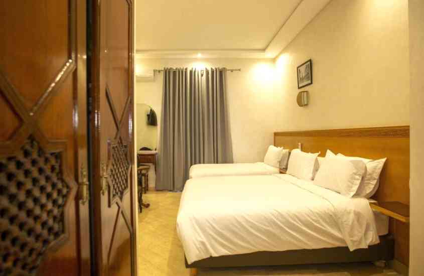duas camas de casal e guarda-roupa de madeira em suíte de hotel em casablanca