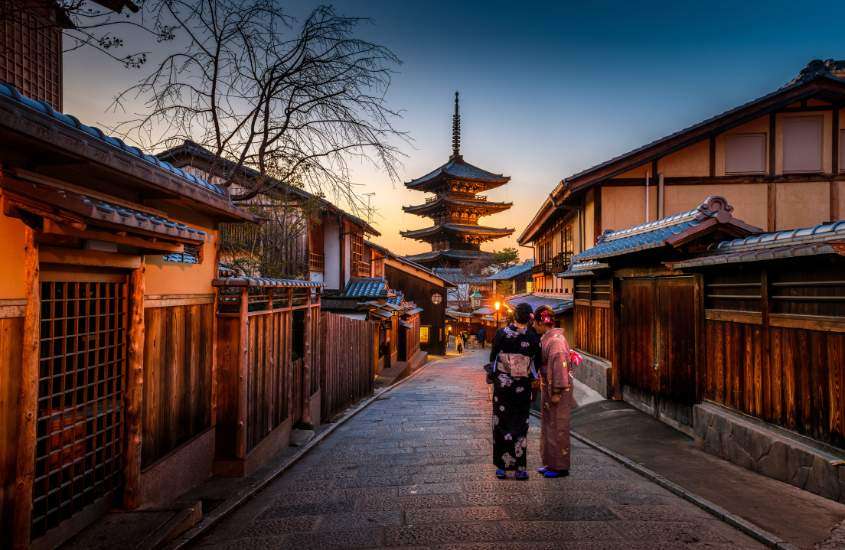 durante entardecer, duas gueixas caminhando em rua de gion, um lugar onde ficar em kyoto
