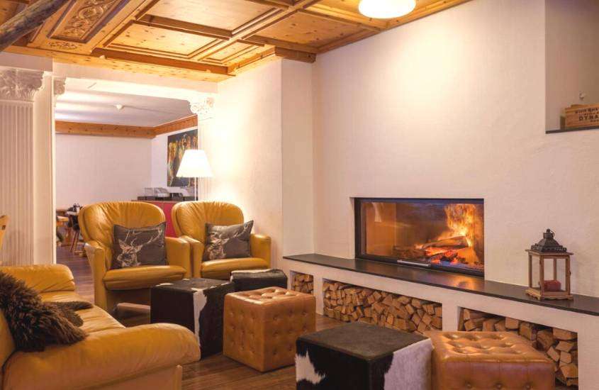 sofá e poltronas amarelas em frente a lareira em suíte de um dos melhores hotéis em st. moritz