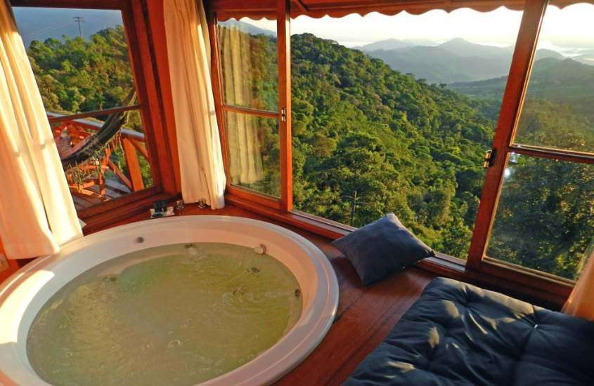 durante o dia, banheira redonda em suíte com vista panorâmica para as montanhas