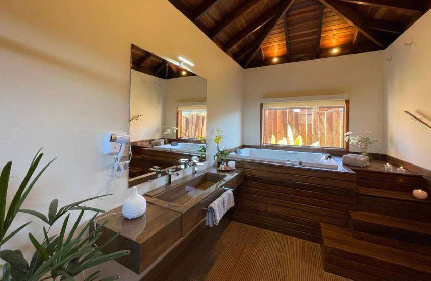 banheiro com paredes brancas, em suíte de uma das pousadas em Visconde de Mauá com hidro quadrada