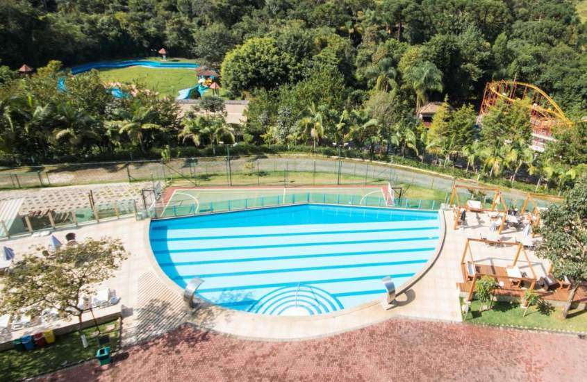 durante dia ensolarado, vista aérea de piscinas e quadras de esportes em complexo de hotel em poços de caldas