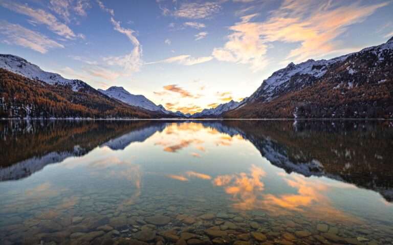 durante entardecer, reflexo de montanhas nevadas em lago cristalino de st moritz suíça