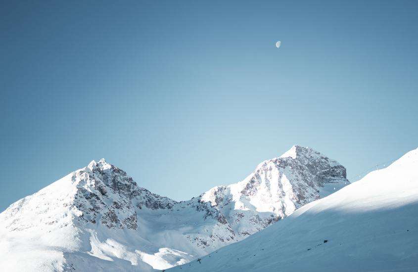 durante o dia, montanha coberta de neve sob céu azul