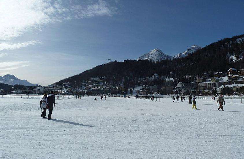 durante o dia, pessoas patinando num lago congelado, atração para quem busca o que fazer em st moritz no inverno