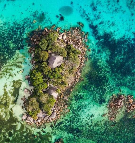 durante o dia, vista aérea de ilha cercada por mar cristalino