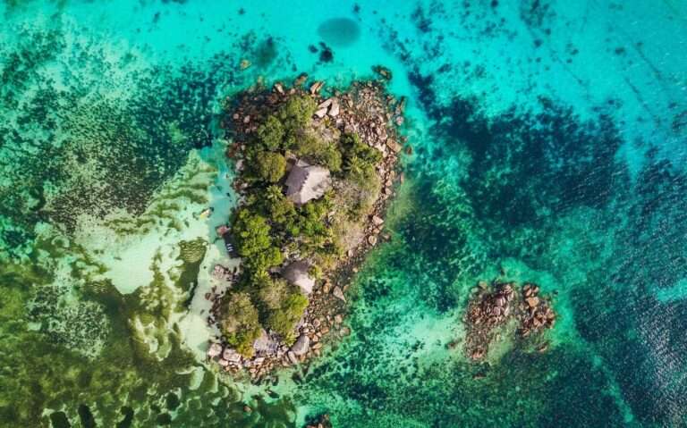durante o dia, vista aérea de ilha cercada por mar cristalino