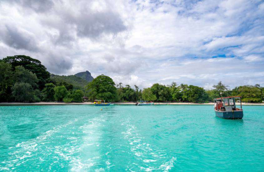 durante o dia, barco em águas azuis de mahé, um lugar onde ficar em seychelles