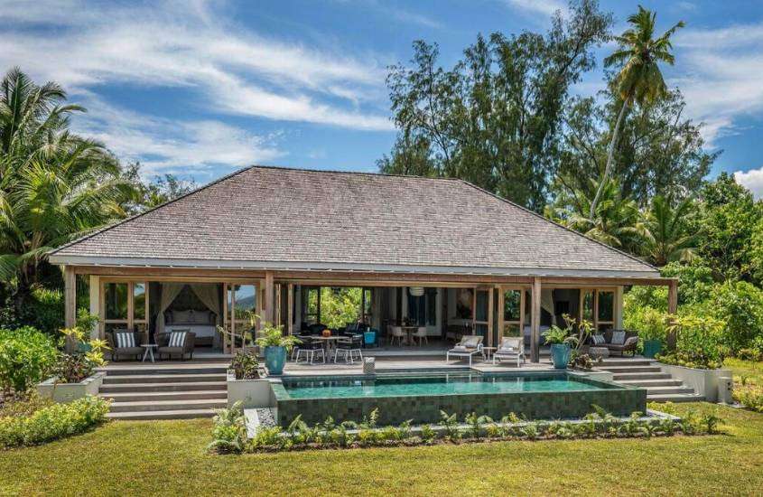 durante o dia, espreguiçadeiras e piscina em quintal de villa de um dos melhores hotéis de Seychelles