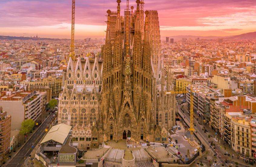 vista aérea durante o entardecer da Basílica da Sagrada Família, um ponto turístico da espanha com torres altas e detalhes ornamentais