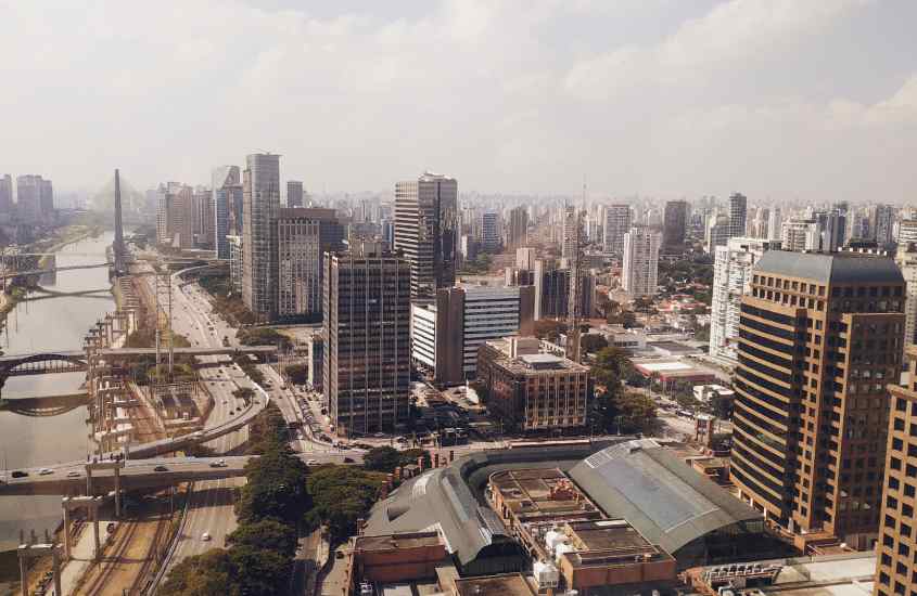 Em um dia de sol, vista aérea de rio, árvores, pontes e prédios na cidade de são paulo, destino para o ano novo 2024