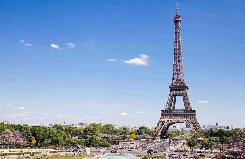 Durante o dia, vista aérea da Torre Eiffel, o icônico monumento de Paris, em meio a edifícios e árvore