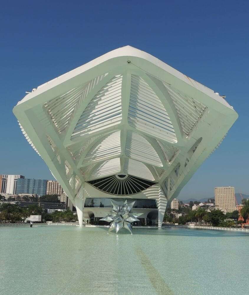 Construção futurista do Museu do Amanhã durante o dia, à beira de um espelho d'água