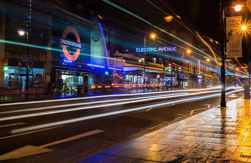 durante a noite, letreiros de lojas iluminadas em Brixton, um lugar onde se hospedar em Londres.