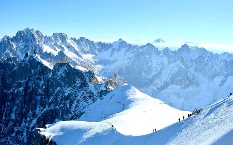 durante dia ensolarado, vista aérea de pessoas em topo de montanha nevada