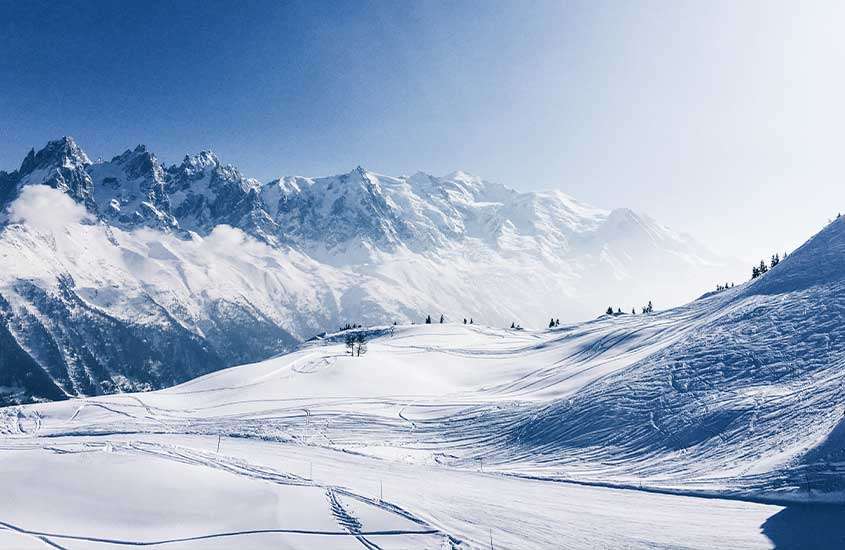 durante dia ensolarado, pessoas caminhando em montanha coberta de neve em Chamonix, um dos melhores lugares para esquiar na europa