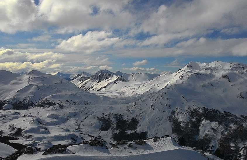 durante o dia, vista aérea de diversas montanhas cobertas de neve em Cerro Castor