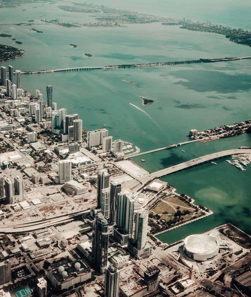 Durante o dia, vista aérea de vários prédios e arranha-céus com vista para o mar em Fort Lauderdale