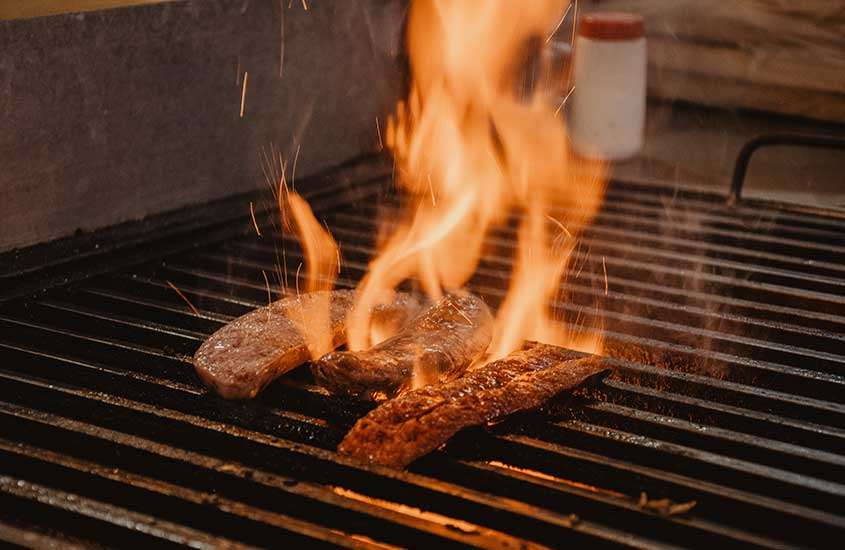 Bife de chorizo suculento sendo grelhado em um lugar onde comer em bariloche