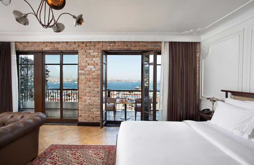 durante o dia, sofá e cama de casal em suíte de hotel em Istambul com varanda e vista para o mar