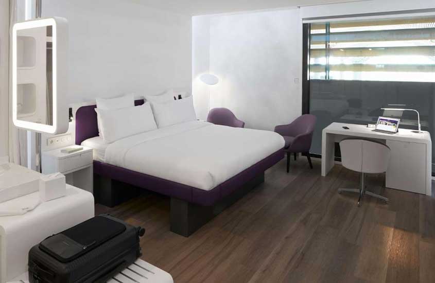 cama de casal, poltronas e mesa de escritório em suíte de um dos melhores hotéis perto do Aeroporto de Istambul