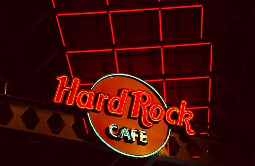 Placa vermelha iluminada com o logotipo "Hard Rock Cafe", em restaurante com ceia de réveillon em fortaleza