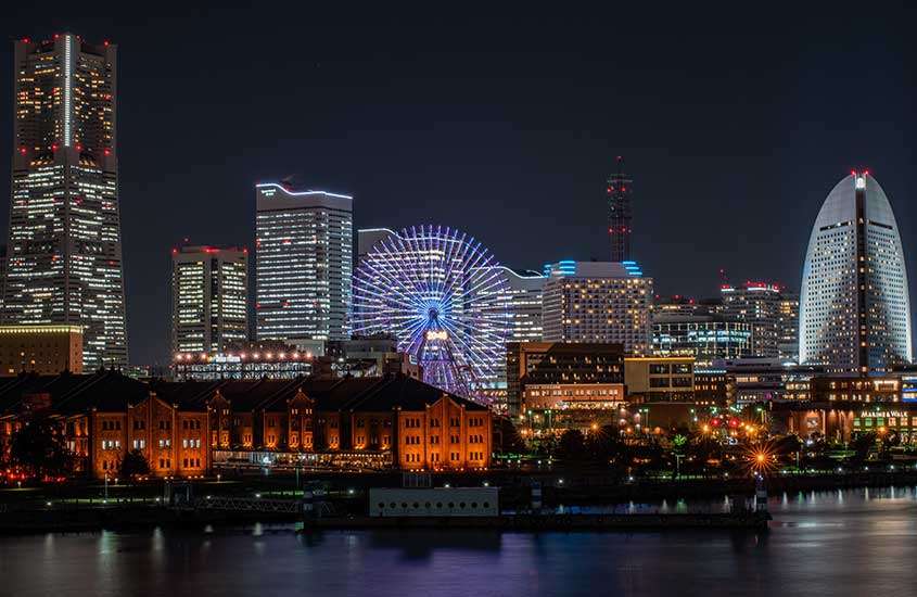 Vista aérea noturna de luminados às margens de porto em Yokohama, uma das cidades perto de tokyo.