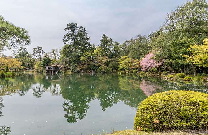 durante um dia nublado, lago rodeado de árvores em Kanazawa, uma das cidades próximas de tokyo.