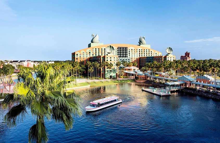 durante um dia ensolarado, vista aérea de barco passando em frente a rio de um dos melhores hotéis da Disney em Orlando.