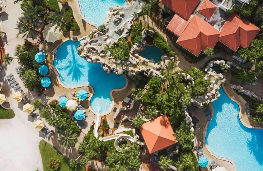 durante um dia ensolarado, vista aérea piscinas em formato de lago em um dos resorts da disney em orlando.