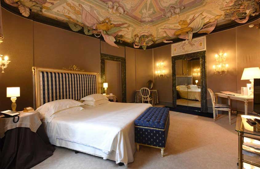cama de casal em suíte de hotel em Veneza com estuques e afrescos dos séculos XVII e XVIII.