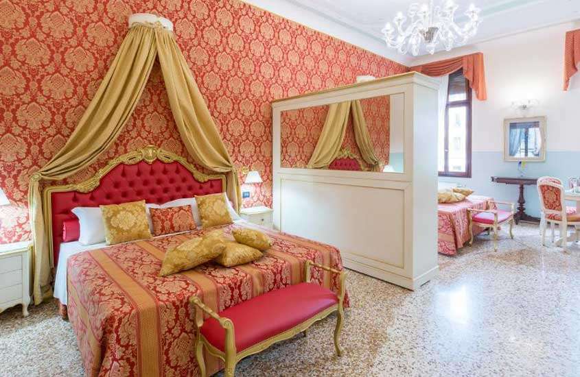 duas camas de casal, cadeiras e mesas em suíte espaçosa de um dos melhores hotéis em veneza