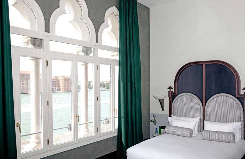 cama de casal em suíte de hotel em veneza com vista do canal, durante o dia