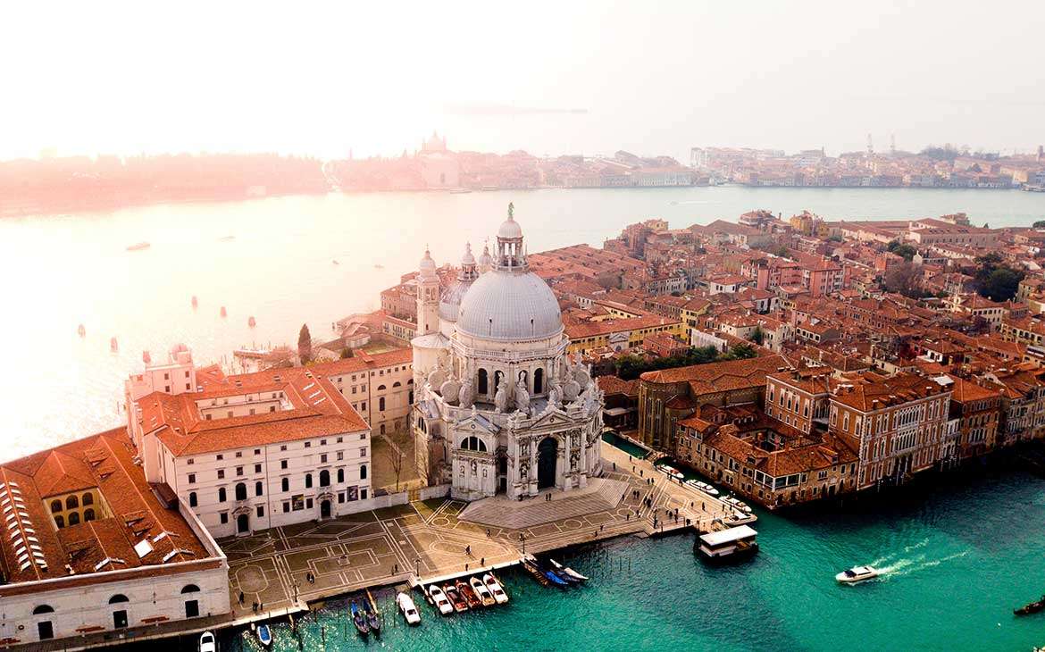durante o dia, vista aérea de prédios às margens de canais em Veneza.
