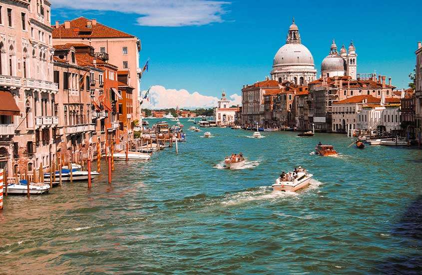durante um dia ensolarado, barcos passando em um dos canais de Veneza.