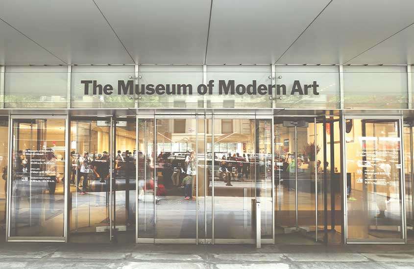 Fachada do museu de arte moderna, com portas de vidro e letreiro preto