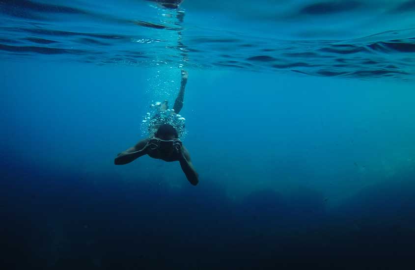 pessoa no fundo do mar, mergulhando com snorkel.