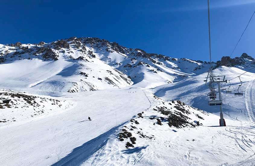durante um dia ensolarado, montanha coberta de neve na estação de esqui Los Puquios, um dos melhores atrativos para quem vai viajar para Mendoza com crianças.