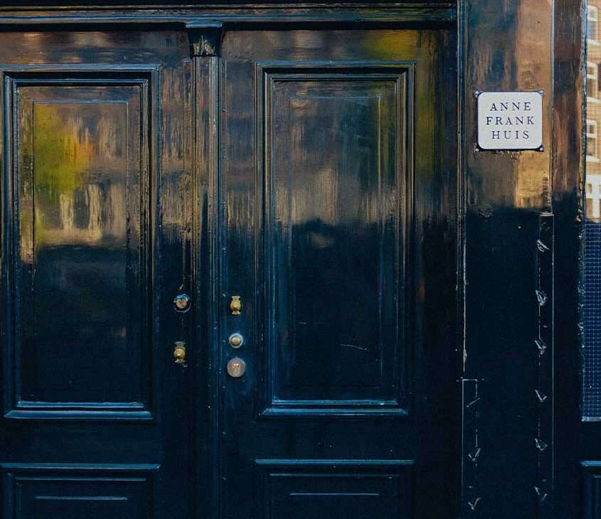portas azuis, com plaquinha de metal informando que é a casa de Anne Frank