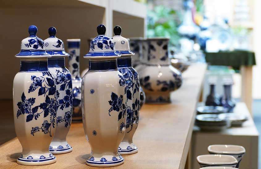 louças de cerâmica brancas e azuis, em cima de prateleira de madeira